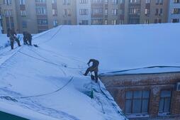Процесс очистки кровли от снега и наледи